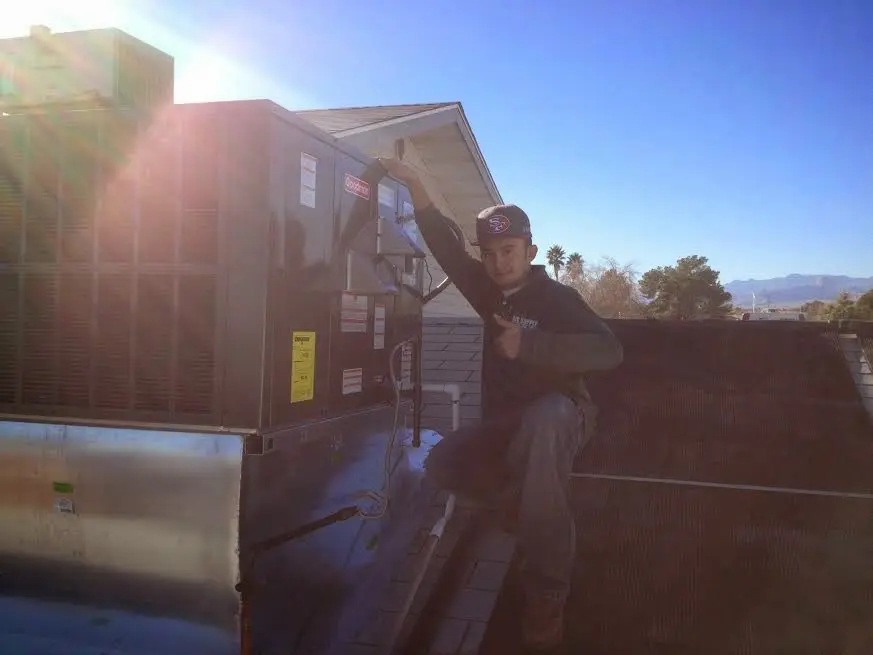 HVAC technician performing AC Tune-Up on a rooftop unit in Benton Harbor